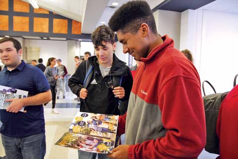 Habersham Central High School (HCHS) seniors Brett Browner, right, and Jose Bravo, center, check out a brochure from Georgia Southern University at the annual College PROBE Fair. About 50 colleges and universities visited HCHS Thursday to connect with students about post-secondary education opportunities. (Photo/ERIC PEREIRA)