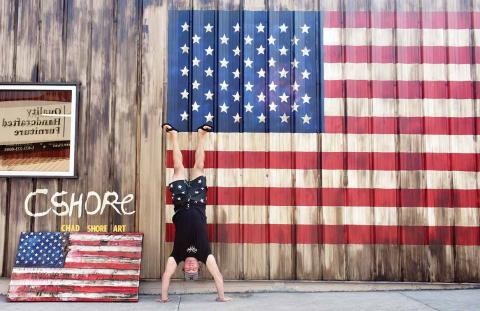 Artist Chad Shore does a headstand in front of his work. (Photo/Chamian Cruz)