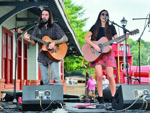 “Leaving Lennox,” comprised of Mick Hambly and Lauren Val, perform on stage in downtown Cornelia singing a song to the hundreds of attendees of the Big Red Apple Festival Saturday, Sept. 28. They sang a mix of covers and original songs. (Photo/CHAMIAN CRUZ)