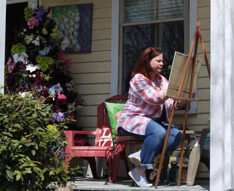 Amy Sullivan paints on the front porch of Canvas and Cork, a wine tasting room and art gallery located on the corner of Dahlonega’s downtown Hancock Park. PHOTO BY CAITLIN JETT
