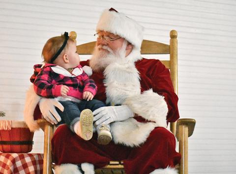 Santa Claus and 14-month-old Morgan Phillips of Demorest share a moment at the Christmas in Mt. Airy event Tuesday. Photo by Chamian Cruz