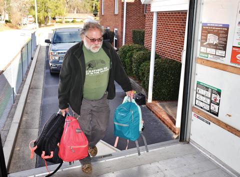 Volunteer Jack Treadman carries backpacks to the truck as part of Backpacks for Appalachia, a program to get gifts and supplies to kids in need at Christmastime.