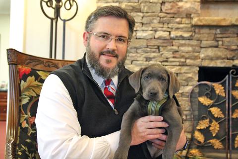 Hillside Memorial Chapel and Gardens owner Brent Tolbert hold Shiloh, the newest addition to their workforce.