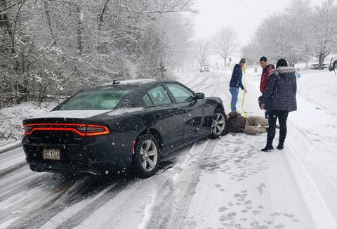 Motorists try to help each other during the icy conditions Saturday on Level Grove Road. Snow fell quickly around lunchtime while many drivers were out doing their weekend errands, causing many minor accidents.