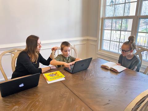 Clarkesville Elementary teacher April Jones helps her children Zachary, 7, and Corie, 12, work on their school assignments from home. Jones teaches her second graders remotely as well during a busy daily routine.