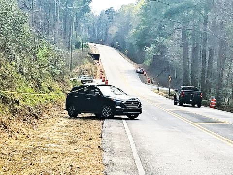 A car visiting the Panther Creek trailhead from the metro Atlanta area tries to pull out into the road Friday afternoon while getting stuck on the police line set up to deter visitors.