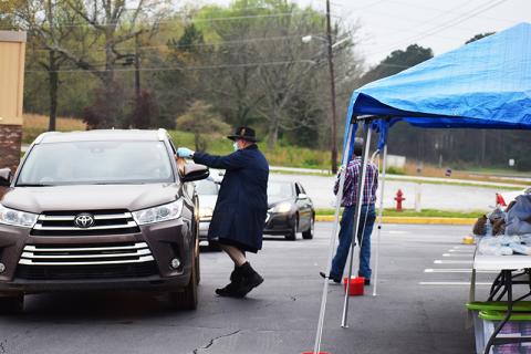 The Habersham Seventh Day Adventist Church gave away bags full of medical masks, gloves, a bottle of hand sanitizer, a digital thermometer and books to anyone that drove through the Quality Foods parking lot Sunday at 9 a.m. Shown from left are Dortch Williams and Jorge Guillen. Not pictures are Rodney Sykes, Pat Williams and Rodney Williams, who also helped with the giveaway. Photo by CODY ROGERS/Staff