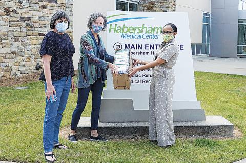 From left, Margie Williamson and Janice Mangimelli from Bethlehem Baptist Church offer mask covers to Kesha Clinkscale, Vice President of External Affairs at Habersham Medical Center.