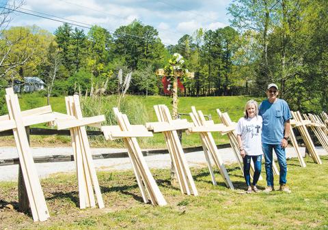 Sandy and Jimmy Turner stand with dozens of wooden crosses they’ve built as part of the “Faith Not Fear” movement. The crosses are free of charge to anyone who wants one. Donations for materials are accepted.