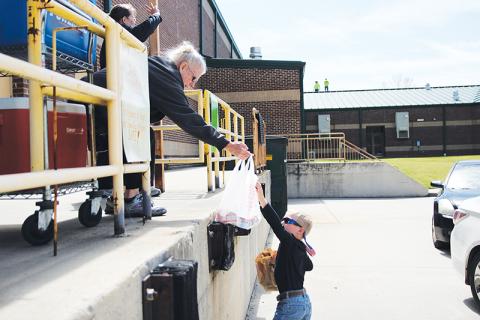 Demorest Elementary School nutritionist Mary Edder hands out meals to McCoy Wilson during Wednesday’s lunch pickup. Photo by Eric Pereira