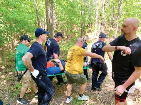 Habersham County EMTs help carry Commissioner Dustin Mealor out of the woods after he suffered a serious foot injury while mountain biking last weekend.