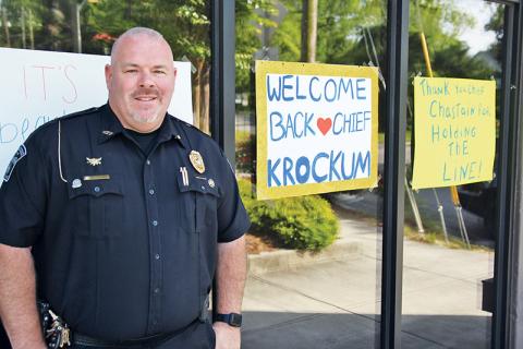 Demorest Police Chief Robin Krockum stands outside his department with signs showing community support.