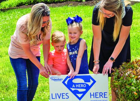 Jessica Little, Dallas Little, 6, Cash Hester, 3, and Kristen Hester place a “hero” sign in front of a Clarkesville home on Monday. The signs are part of an effort to recognize and thank healthcare workers who are working on the “front lines” of the current COVID-19 pandemic.