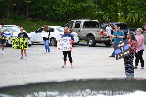Jennifer Austin, Heather Dotson and Saylor Krockum hold up signs of protest at the Demorest gathering April 28.
