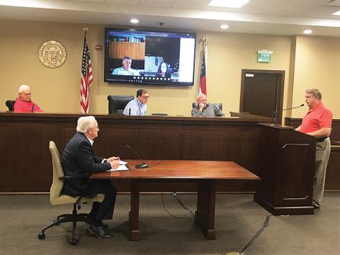 County Manager Phil Sutton (bottom left) along with Commissioners Jimmy Tench, Stacy Hall and Tim Stamey (from left on bench) listen to Banks County Fire Chief Steve Nichols discuss radio systems on Monday morning.