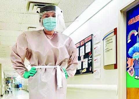 A staffer shows off one of the new gowns Habersham Medical Center purchased from Ford Motor Company.