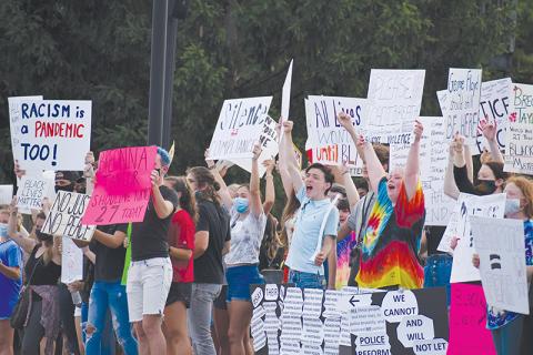 Demonstrators made their voices heard through signs, chants and songs Friday night in Clarkesville as they spoke out against racism. Photo by CODY ROGERS