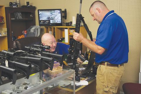 Country Boy Sports owner Kerry Stephens assists customer Kipp Dowdy with the purchase of his new rifle. 