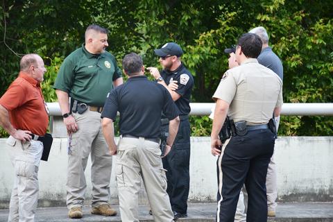 Officers discuss the body found in Clarkesville on Thursday afternoon.