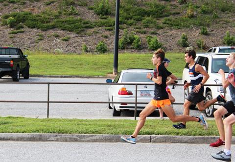Andrew Kivett (running in front) leads Habersham Central’s cross country team in several different ways this season.