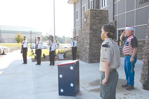 Grant Reeves VFW Post 7720 Commander Bill Miles (right) and Eagle Scout Joseph McNair stand at attention while the VFW Honor Guard plays “Taps” at Tuesday’s dedication ceremony for the flag retirement boxes.