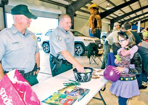 Georgia Department of Natural Resources officers Chad Chambers (left) and Joe Hill offer candy to a cool cat at last year’s E-911 Halloween event in Habersham County. The event has been cancelled for this year due to lingering COVID-19 concerns.