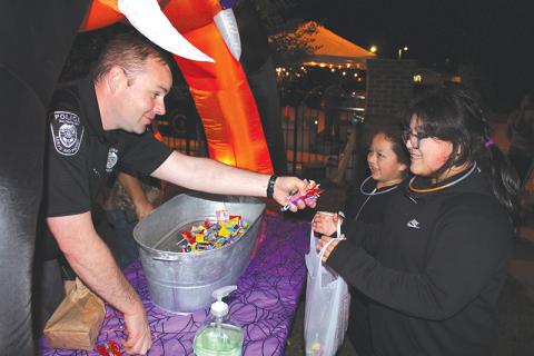 Baldwin interim police chief Matt Nall hands out candy to Bere Ortega and Elizabeth Aguilar at the final trunk-or-treat stop during Baldwin’s fall festival Wednesday night. The festival, hosted by Baldwin Baptist Church and the Baldwin Police and Fire departments, saw much of the community come out for a night of trunk-or-treating, food and fellowship. 