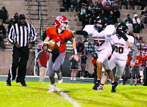 Judge Wilbanks (57) pressures Indians' quarterback Tripp Underwood (14) on one of his only pass attempts of the night to keep the game knotted at 14-14 going into halftime. ISAIAH SMITH/Staff