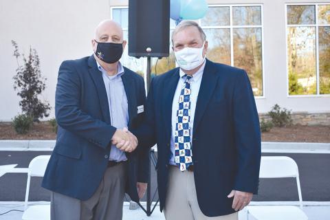 Dr. F. Stuart Sanders (right) is congratulated by Habersham County Chamber of Commerce Chairman Sidney Roland III after a legacy wall was erected in his honor Tuesday at the new Rehabilitation & Orthopedics Complex at Habersham Medical Center. CHAMIAN CRUZ/Staff