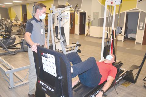 Habersham Medical Center rehab employees Jim McGahee (left) and Zachary Robertson demonstrate a new leg press machine that is part of the arsenal of physical therapy equipment at the brand new Rehabilitation & Orthopedics Complex.