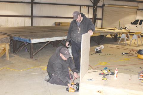 Habersham County Sheriff’s Deputy Jason Eller (left) uses a nail gun to construct a judge’s bench while deputy Paul Jardine (right) holds the wood in place. The pair also constructed a witness stand to be used for superior court in the aquatic center.