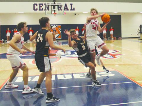 Senior guard Grant Tipton takes absorbs a foul before finishing the layup during Monday night’s Raider victory over Prince Avenue.