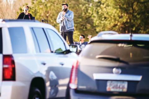 Eric and Misty Wilcox sing at The Torch’s drive-up prayer service March 22 at one of the first socially-distanced worship services during the COVID-19 crisis.