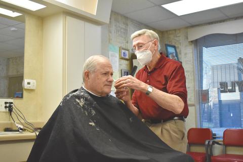 Jim Daniel works on a haircut Thursday morning for one of his longtime customers, Arthur Howard. Daniel has cut hair at his shop in Cornelia since 1961.