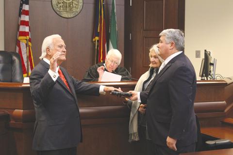 Bubba McDonald of Clarkesville (left) takes his oath of office as a Public Service Commissioner from Judge Joseph Booth (center) while his wife Shelley and son State Rep. Lauren McDonald III stand alongside him.