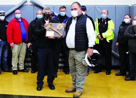 Habersham County EMS Director Chad Black (left) presents Jeff Cain (right) with a plaque commemorating his years of service while surrounded by the County's EMS workers. Black also thanked Cain for his work in helping merge the county's firefighters and EMS into a single department like it is today.