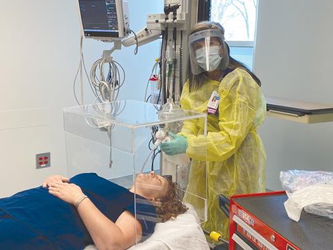 Jamie  Mentzer uses an  intubation box and practices placing a breathing tube into a COVID-19  patient that is unable to breathe on their own. HABERSHAM MEDICAL CENTER/Submitted