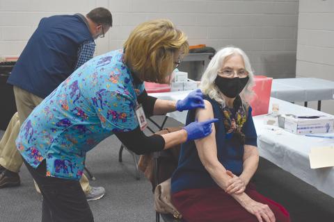 Pennie Ansley, a registered nurse with the Habersham County Health Department, administers the second dose of the COVID-19 vaccine to Marcia Brazinski on Wednesday. The vaccination took place at the Ruby Fulbright Aquatic Center in Clarkesville. Her husband, Franklin Brazinski, sits behind her. 