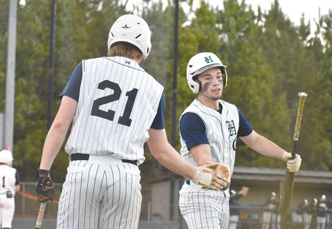 Logan Bogue congratulates Azzi Cervantes after scoring one of the Raiders’ five runs in the second inning of Wednesday’s game against the Franklin County Lions.