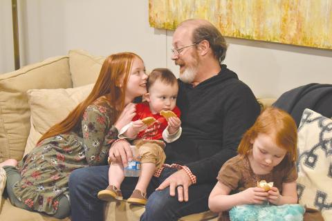 Randy Chester shares a smile with daughter Paloma as little guy Rune samples the cookies and Azalea checks out a cupcake to celebrate their new space.