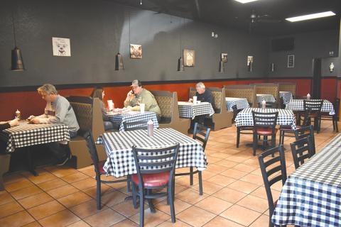 Customers enjoy a meal at Wolf Creek BBQ’s new location since a fire destroyed its former building in Cornelia and forced it to close for four months.