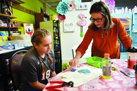 Splashe PYOP Art Studio Owner Valerie Wheeler, right, helps Blair Huddleston during a glass fusing class.