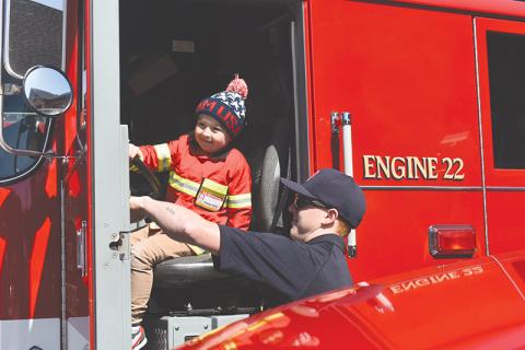 Four-year-old Sawyer Stille takes the opportunity while he’s dressed as a firefighter to honk a real fire truck at the new Cornelia South Station on Saturday.