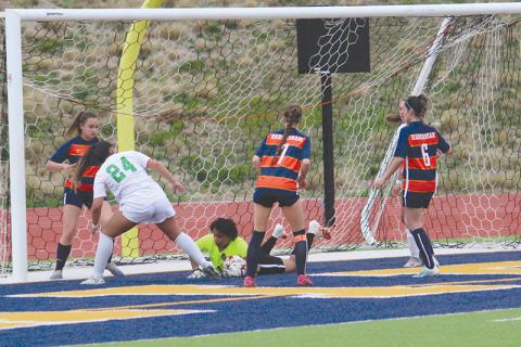 Nykerrah Brown dives to smother a shot from a Buford forward during Tuesday night’s contest. Brown recorded several saves to keep the Lady Raiders within striking distance in the first half.