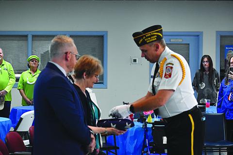 Sharon Krefft is presented with an American Flag, along with a buddy poppy and a three-shell casing from the three-round volley in honor of her husband Calvin at his celebration of life ceremony. VFW member Jim Morgan presented her with the gifts.