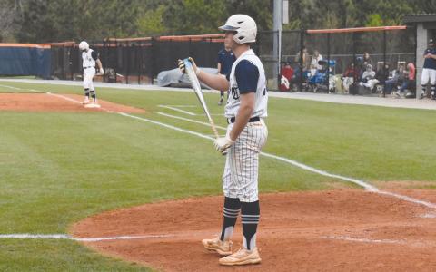 Sutton Dover takes a sign from head coach Chris Akridge before stepping back into the box. Dover went 4-6 over the Raiders’ two state playoff games with two RBI and a home run. ISAIAH SMITH/Staff 