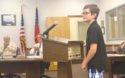 Erik Jordan, a fourth-grade student at Woodville Elementary School, read his award-winning poem to the Habersham County Board of Education on Monday, to the delight of board members Robert Barron and Doug Westmoreland. CHAMIAN CRUZ/Staff 