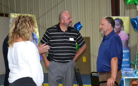 Superintendent Matthew Cooper talks with John Fair, Chief of Staff of Peach State Credit Union, at the Tim Lee Boys & Girls Club open house on June 17. BRIAN WELLMEIER/Staff