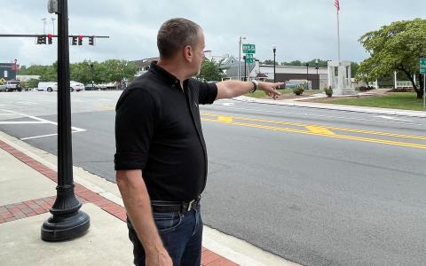 Lew Oliver gestures toward the square he plans to redevelop in downtown Clarkesville. BRIAN WELLMEIER/Staff