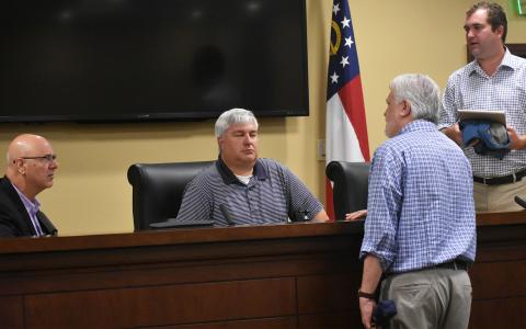 Habersham County Airport commissioners Lawrence Bridges, D. Higgins, Ken Schubring and Chris Limbach talk amongst each other after the meeting Monday morning. CHAMIAN CRUZ/Staff